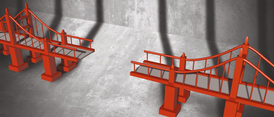 A red bridge missing the middle section, shown against a cement background