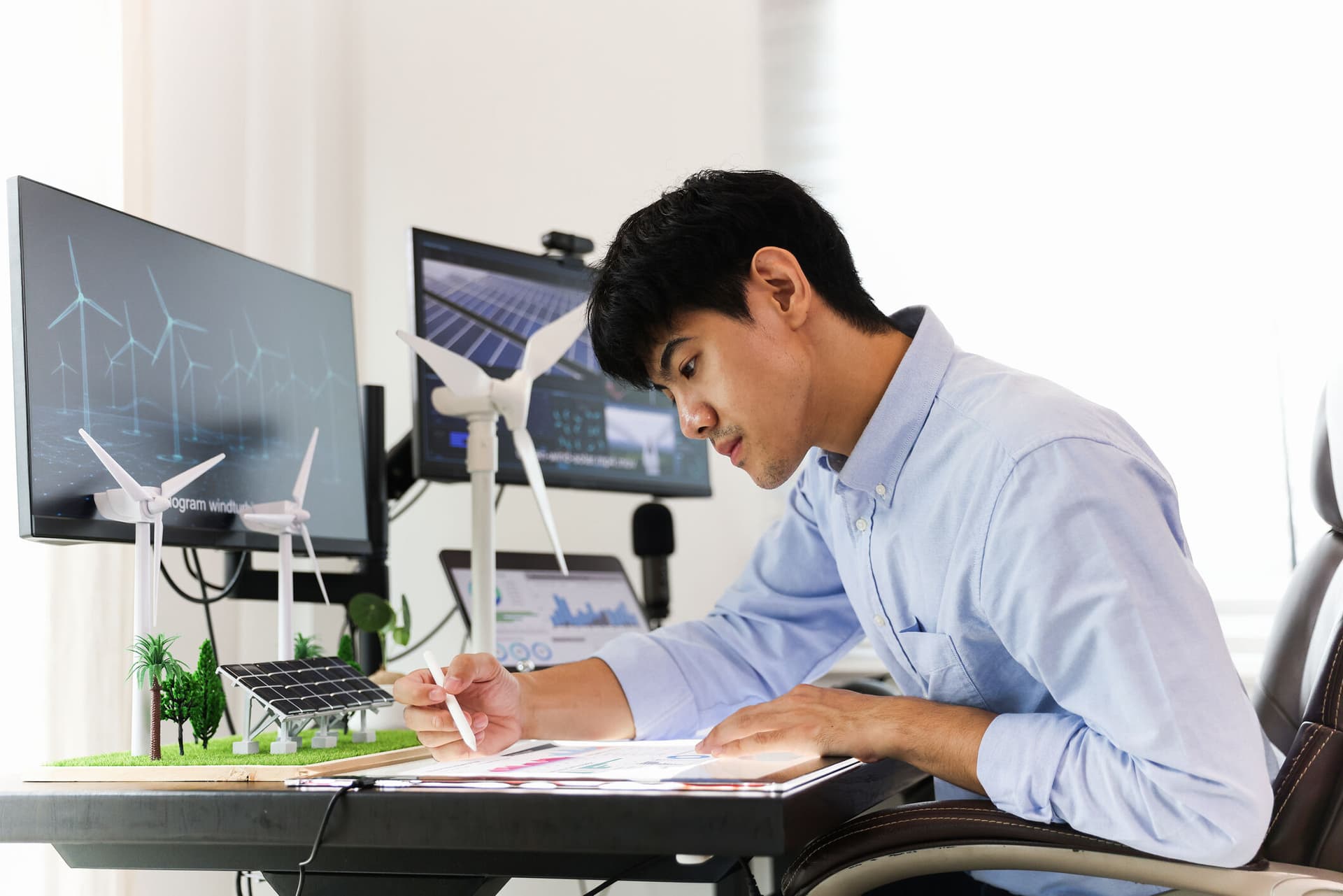 Young smart design engineer design Green energy system , freelance engineer work at home office , engineer working on the wind turbines project
