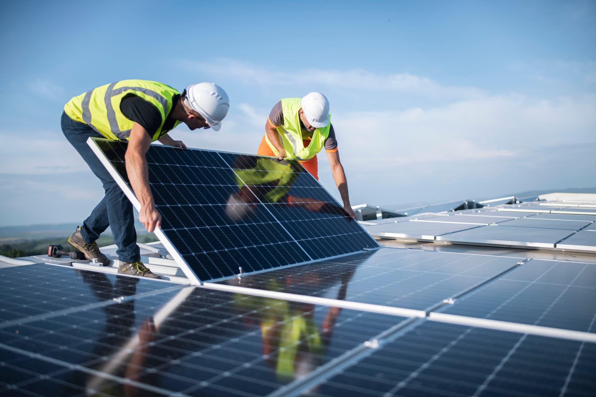 Team of engineers installing solar panels on roof